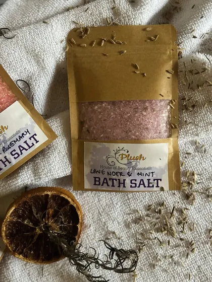 A close-up of the Lavender & Mint bath salt, sprinkled with dried lavender buds. This blend is perfect for melting away stress after a long day.
