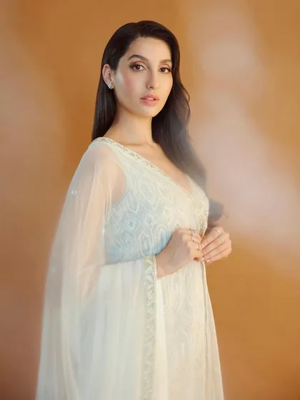 Nora Fatehi looks ethereal in this white peplum and sharara set by Ritika Mirchandani. This is a great example of fusion wear, blending traditional embroidery with a modern silhouette for a chic, celebratory look.