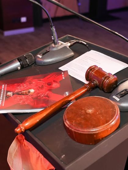 The auctioneer's gavel and booklet on the podium. This detailed shot captures the tools of the trade for a high-stakes auction event we produced.