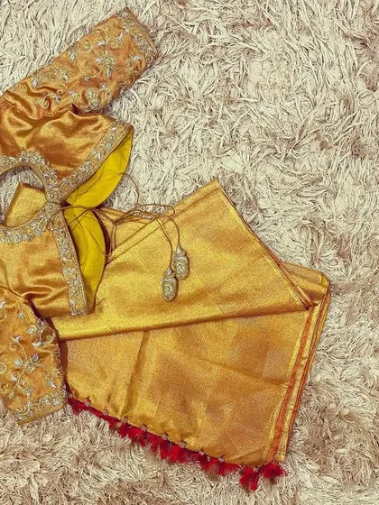 Another angle of the gold embroidered blouse, showing the detailed work on the sleeves and the elegant tassels.