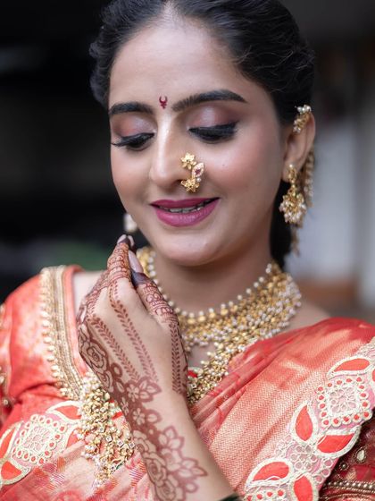 A detailed shot of the traditional Maharashtrian nath and the layered gold necklace, essential pieces for completing the bridal look.
