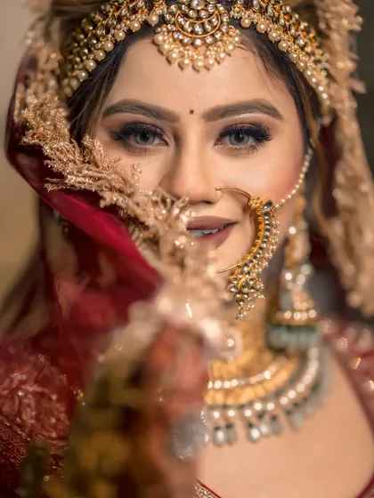 A bride's portrait is more than a picture; it's a story of her grace and strength. We use creative lighting and composition to capture the soul behind the smile, as seen in this striking close-up of our bride Gurbani, her eyes telling a story of dreams and devotion.