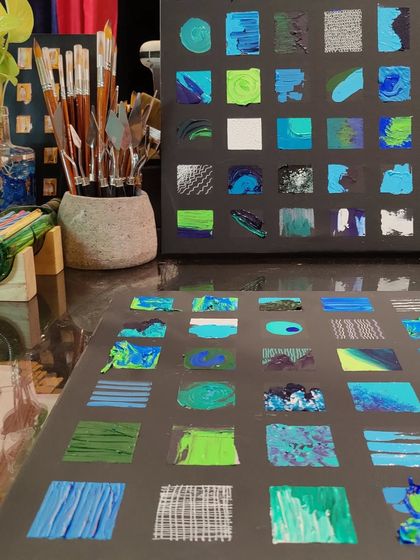 A close-up of the studio table during the creation of the grid paintings, showing the palette knives and brushes used to create the varied textures.