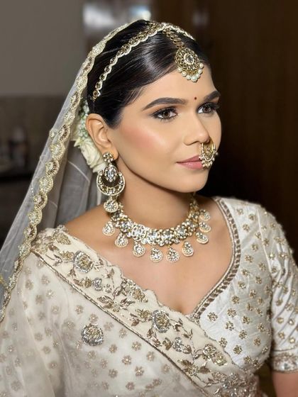 The complete look, with the veil placed over the floral bun. This hairstyle provides a secure and beautiful base for holding a bridal dupatta or veil.