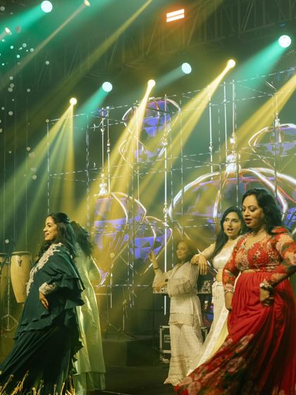 A candid moment of joy as the family dances together on stage during the sangeet night.
