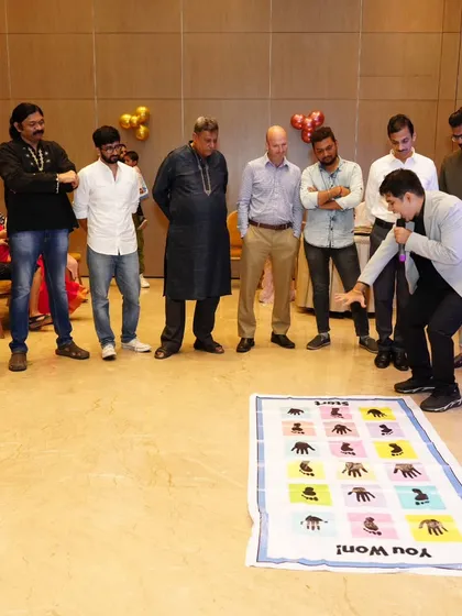 Explaining the rules of the hands and feet mat game. I make sure everyone knows how to play before the chaos begins.
