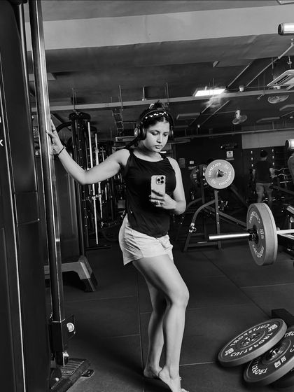 A black and white photo capturing a moment of reflection in the gym. Every session is a chance to get stronger than you were yesterday.