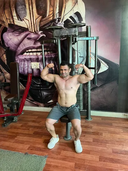 Posing is an art. After a tough workout, I take a moment to practice a double bicep pose, demonstrating the muscle control and presentation that turns a great physique into a winning one.