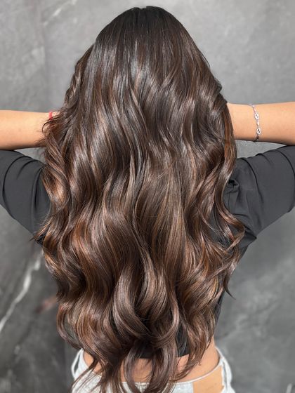 This full-back view shows the artistry of a well-executed balayage. The highlights are placed to create movement and the illusion of thicker, more voluminous hair.