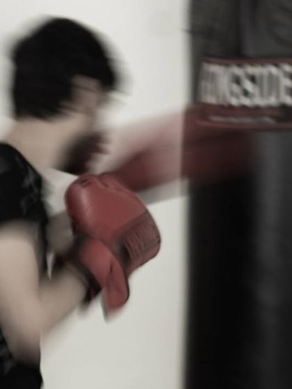 A blur of motion as a punch connects with the heavy bag. This is the kind of adrenaline rush you can expect in our kickboxing sessions.