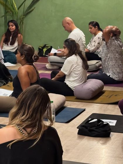 A community dedicated to peace. Participants listen intently during a Yoga Nidra session, using bolsters and cushions for support as they prepare for guided meditation.