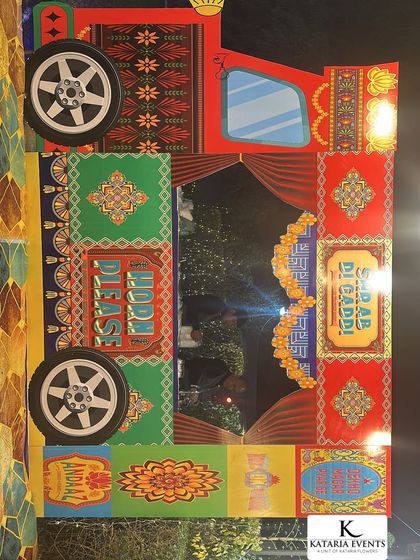 This is a photo booth frame I designed with a colorful Punjabi truck art theme. It includes fun phrases and traditional patterns, making it a unique and interactive element for guests at a Mehendi or Sangeet event.