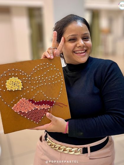 A work in progress. This participant is partway through her landscape string art, with the sun and mountains already taking shape.