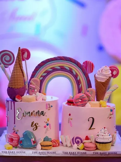 For a "too sweet" themed second birthday, I created this vibrant double-cake masterpiece. It's loaded with fun details like a connecting rainbow, ice cream cones, lollipops, and macarons, bringing pure joy to a child's celebration.