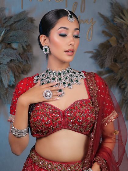 Unveiling bridal elegance that takes your breath away. This look features a clean, sophisticated bun and soft, glowing makeup that complements the diamond and emerald jewelry.