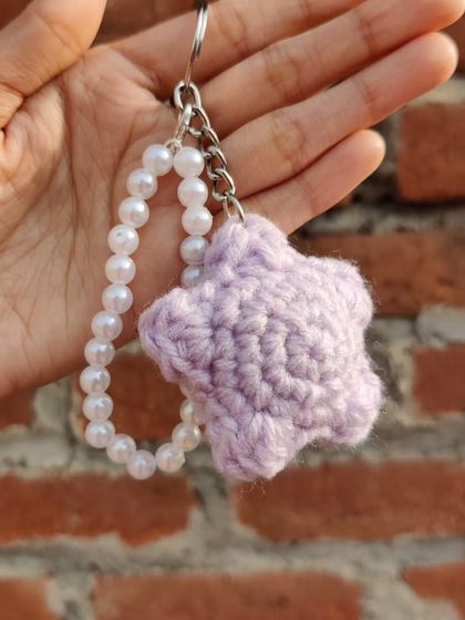 Puffy star-shaped keychains, available in pastel colors like lavender and peach, with an optional pearl strap.