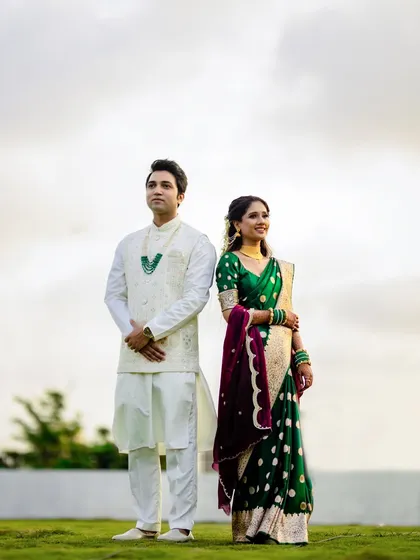 A classic, poised portrait of the couple standing side-by-side. Their regal posture and elegant traditional outfits create a timeless image that speaks of grace and heritage.
