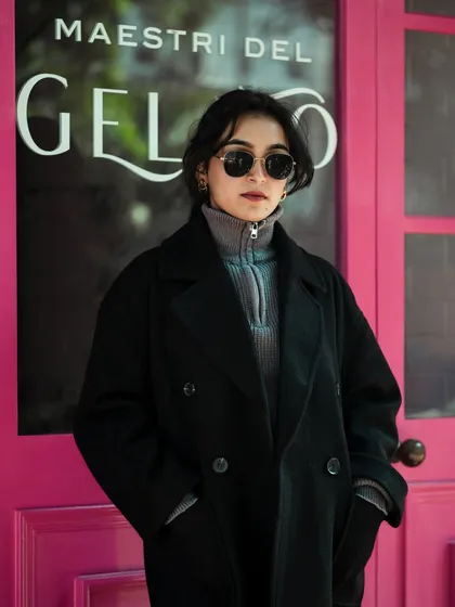 A cool, urban street-style shot featuring a model against a vibrant pink background. We excel at capturing attitude and creating visuals that resonate with modern fashion audiences.