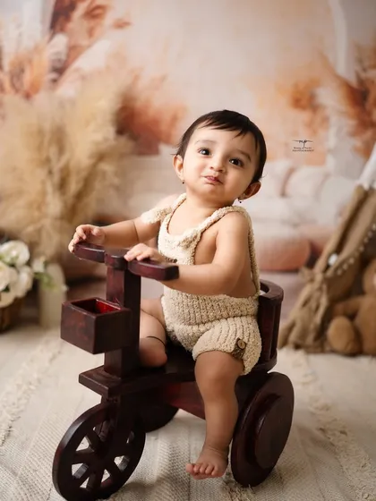 A playful pout from a little boy on his wooden tricycle. Sitter sessions are full of these adorable and fleeting expressions.