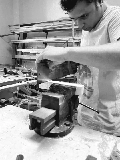 Using a dovetail saw held in a bench vise. This setup provides the stability needed for making the accurate cuts required for joinery.