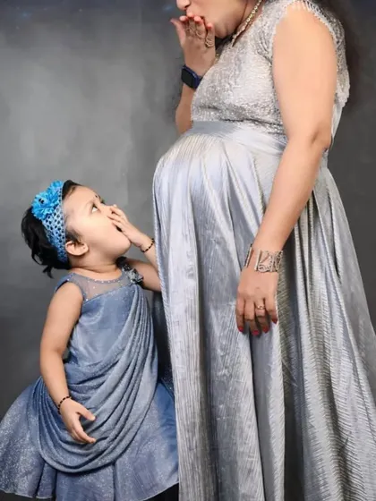Celebrate the bond between mother, daughter, and the new baby on the way. This coordinated set in shimmering grey is perfect for a combined maternity and family photoshoot.