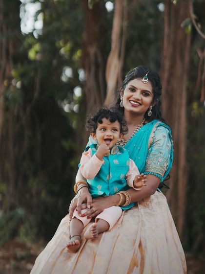 Manasa with her adorable son at his naming ceremony. Her makeup is fresh and pretty, perfect for a happy mom.