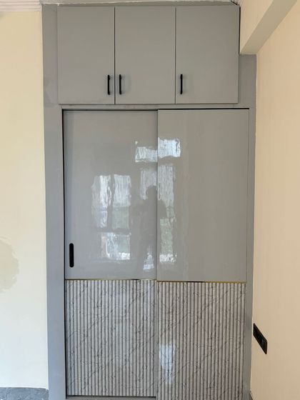 The exterior of the walk-in closet, featuring a modern sliding door with a mix of high-gloss grey and textured marble-finish panels.