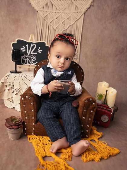 Checking his schedule on a tiny tablet prop. This humorous and adorable shot is from a 'little professional' themed sitter session.