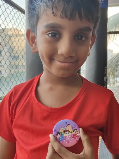 A proud smile from one of our youngest team members. Our kids' program is designed to be welcoming for all skill levels, focusing on personal growth and fun.