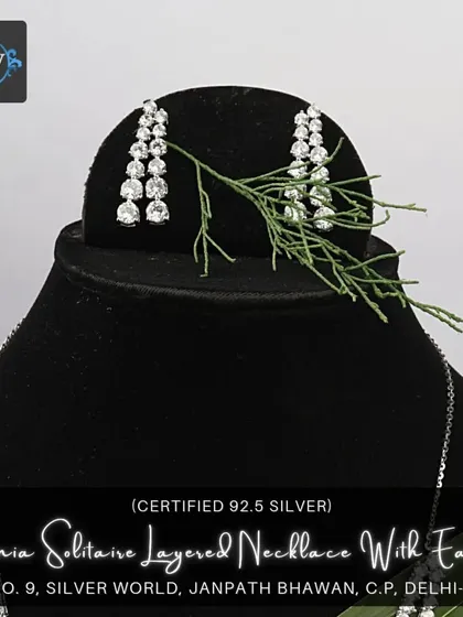 The complete view of our zirconia solitaire layered necklace, paired with matching three-tiered drop earrings. This set offers exceptional sparkle and a sophisticated, modern aesthetic.