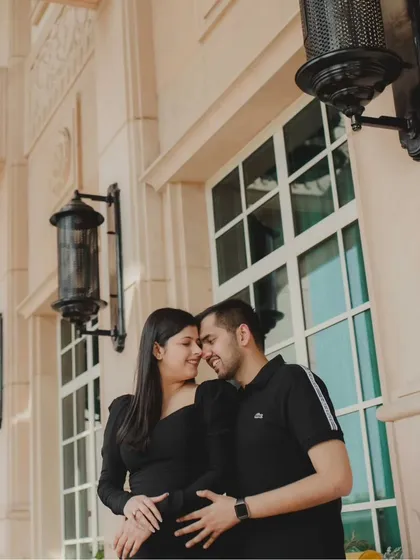 A classic, romantic pre-wedding portrait against an elegant architectural backdrop. The soft lighting and close embrace create a timeless and sophisticated image.