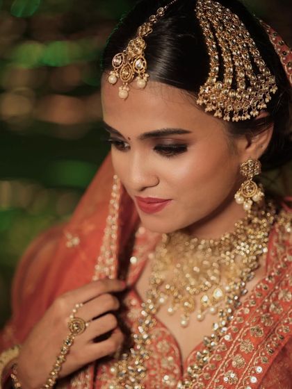 A close-up on the details. This shot highlights the precise eye makeup and the way the jewelry is complemented by the tones used in the makeup.