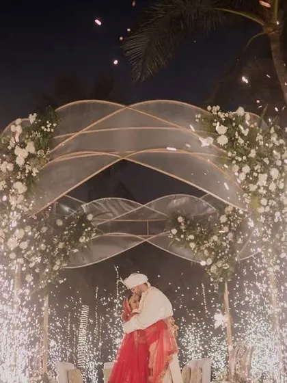 A magical moment captured as the couple is framed by the elegant mandap and sparkling cold pyrotechnics, with the ocean and night sky as their backdrop.