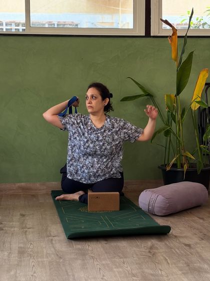 A student uses a strap to work on shoulder mobility, an important part of a well-rounded practice that we emphasize.