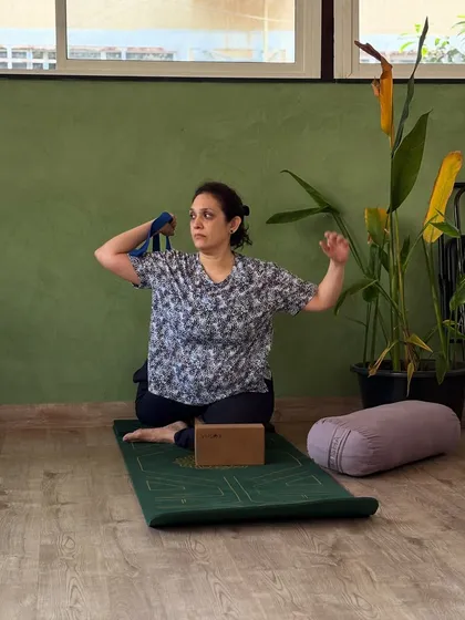 A student uses a strap to work on shoulder mobility, an important part of a well-rounded practice that we emphasize.