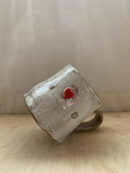 A little love story in clay. A student created this heart-stamped mug and hanging decor, a tale of patience and play.
