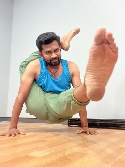 An arm balance variation stemming from a deep hip-opening pose. This requires lifting the body with core and arm strength while maintaining the leg position.