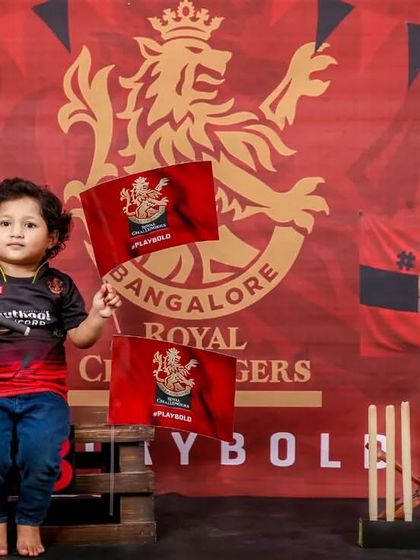 Waving the flag for his favorite team! This toddler is showing his full support in our detailed RCB-themed studio setup.