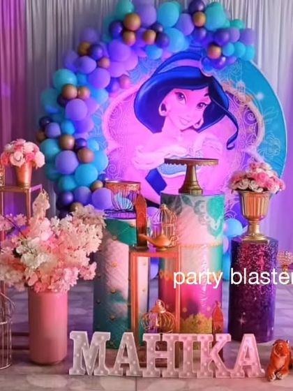 A magical Aladdin theme party for Mahika. This setup features Princess Jasmine, the Genie, and Aladdin props, with a color palette of purple, blue, and gold to evoke the mystery and romance of Agrabah.