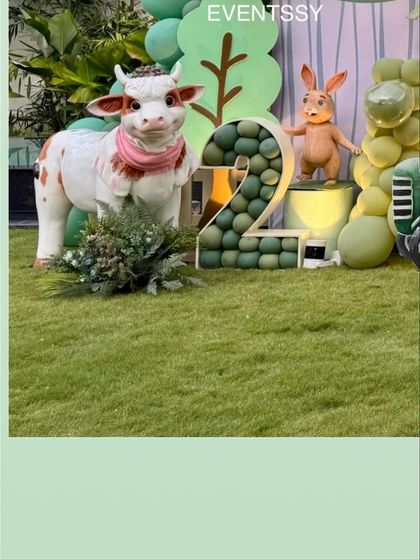 Another view of the farm animal props and the custom marquee number "2." The use of artificial grass and lifelike animal statues makes the theme feel more realistic and engaging for young children.
