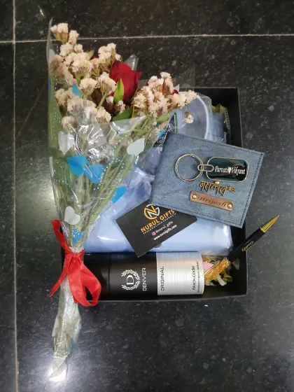 This birthday hamper is designed to make him feel special, containing a personalized denim wallet and keychain, a shirt, a pen, deodorant, and a beautiful bouquet of flowers.