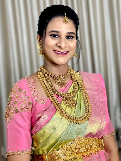 Our client Savitha celebrating her Sreemantham ceremony in a designer tissue silk saree. The pretty pastel green and pink combination is both delicate and festive.