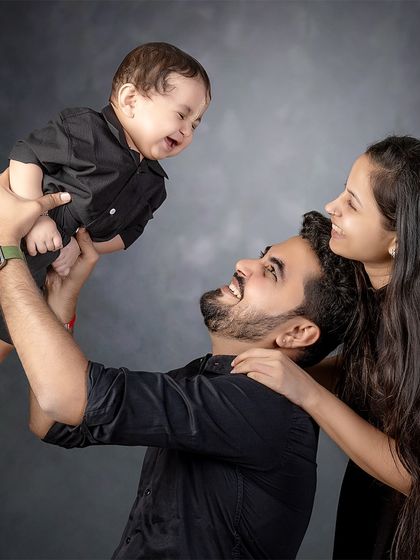 A moment of pure happiness. This candid shot captures the love and laughter shared between parents and their baby, a memory to be cherished forever.