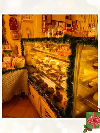 Our dessert display case, framed with festive green garlands, is filled with delicious holiday treats and cakes ready for your celebrations.