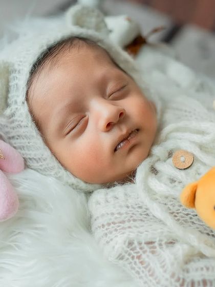 A sweet close-up of the baby sleeping soundly with his teddy bear friends.