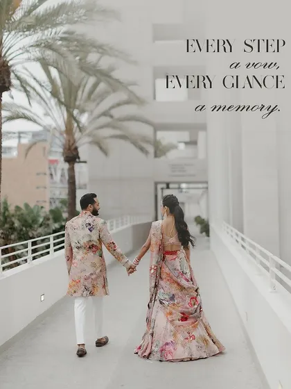 Every step a vow, every glance a memory. The couple walks hand-in-hand, their coordinated floral outfits creating a beautiful, romantic image.