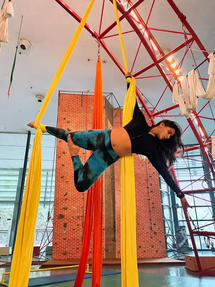 This graceful pose, a variation of an arabesque on aerial silks, highlights the artistry and strength you'll build in our program.