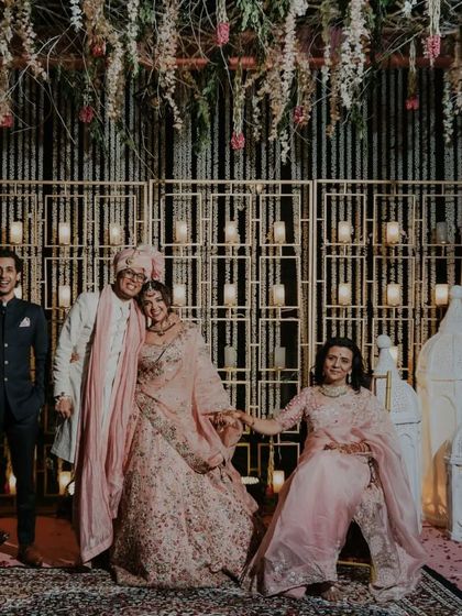 A happy family portrait with the newly married couple and their loved ones against a beautifully decorated backdrop.