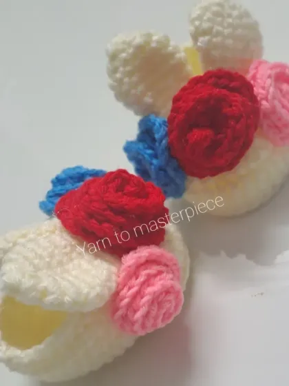 These playful bunny booties are decorated with a cluster of colorful tiny roses, adding a fun and whimsical touch.
