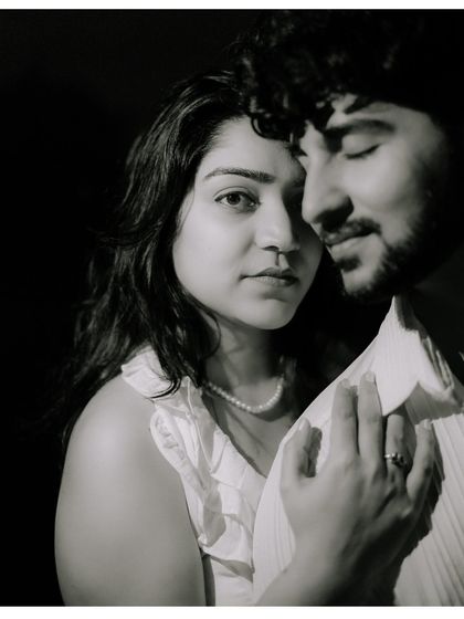 An intense and soulful black and white portrait. The close framing and dramatic lighting create a timeless and emotional image that focuses on their deep connection.